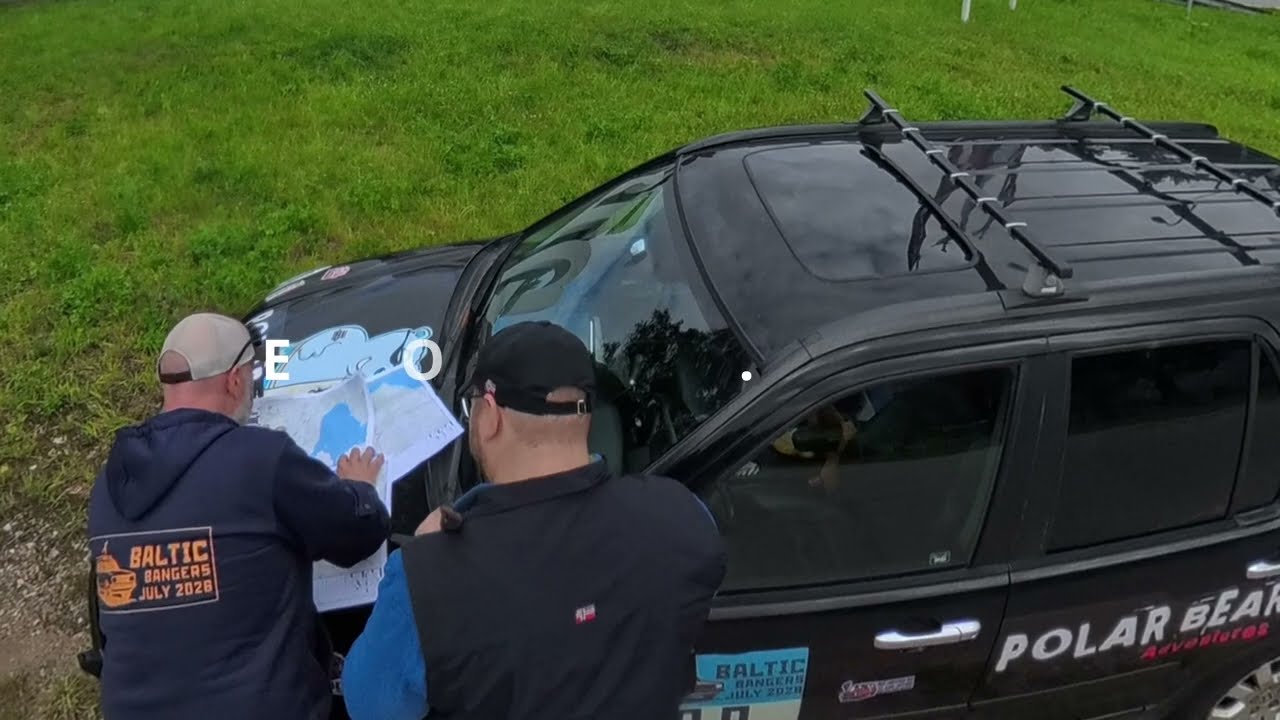 Two Baltic Bangers 2026 participants reading a paper map next to a Polar Bears Adventures car